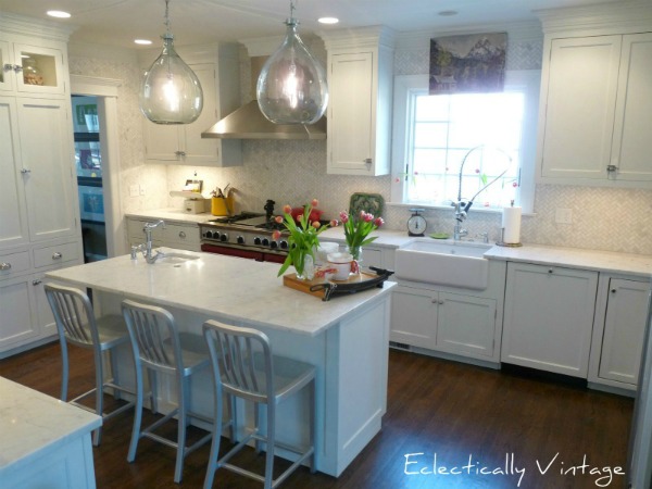 Gorgeous White Farmhouse Kitchen Renovation - love the details like the red stove, herringbone tile to the ceiling and those lights!  kellyelko.com