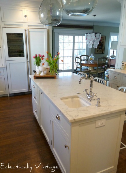 Stunning white kitchen renovation - carrara marble counters, red stove, and glass refrigerator!  ecleticallyvintage.com