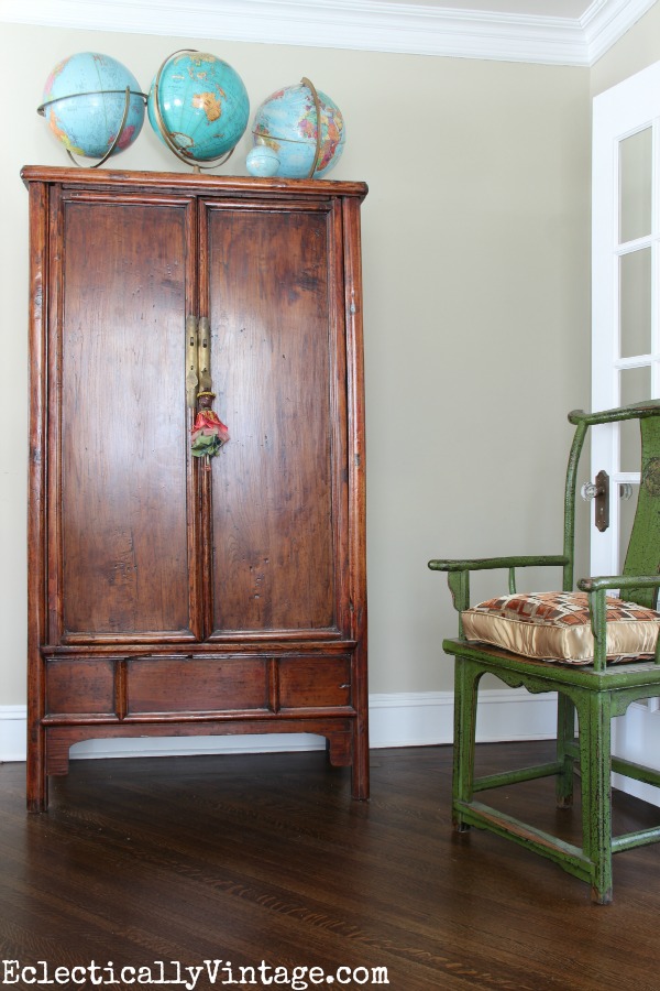 Asian armoire with globe collection - tour this eclectic living room kellyelko.com