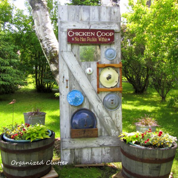 Old door with a vintage pot lid collection - love this garden! kellyelko.com