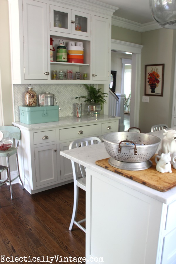 White farmhouse kitchen decked out for summer - love the colorful thermos and barware collections kellyelko.com