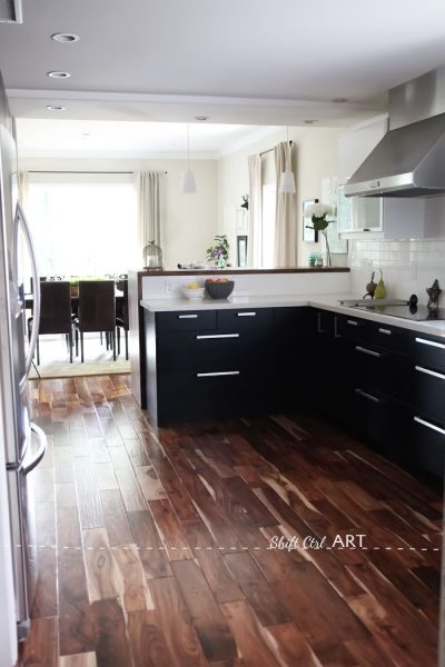 The acacia hardwood flooring is gorgeous in this Ikea kitchen remodel kellyelko.com