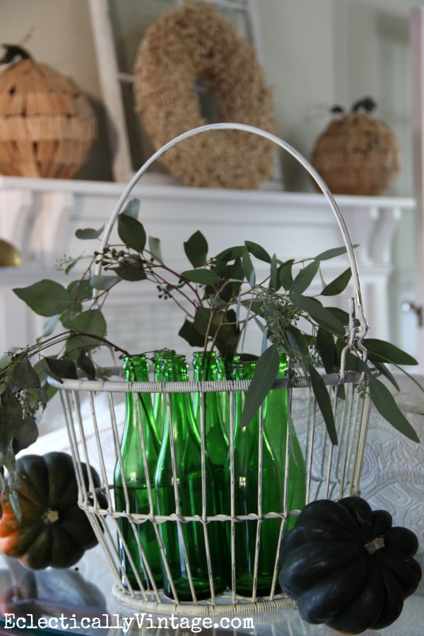 Vintage green glass bottles in a metal basket - gorgeous fall decorating ideas in this home kellyelko.com