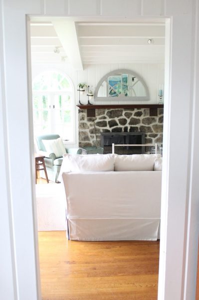 Cozy living room with rustic stone fireplace and planked walls kellyelko.com