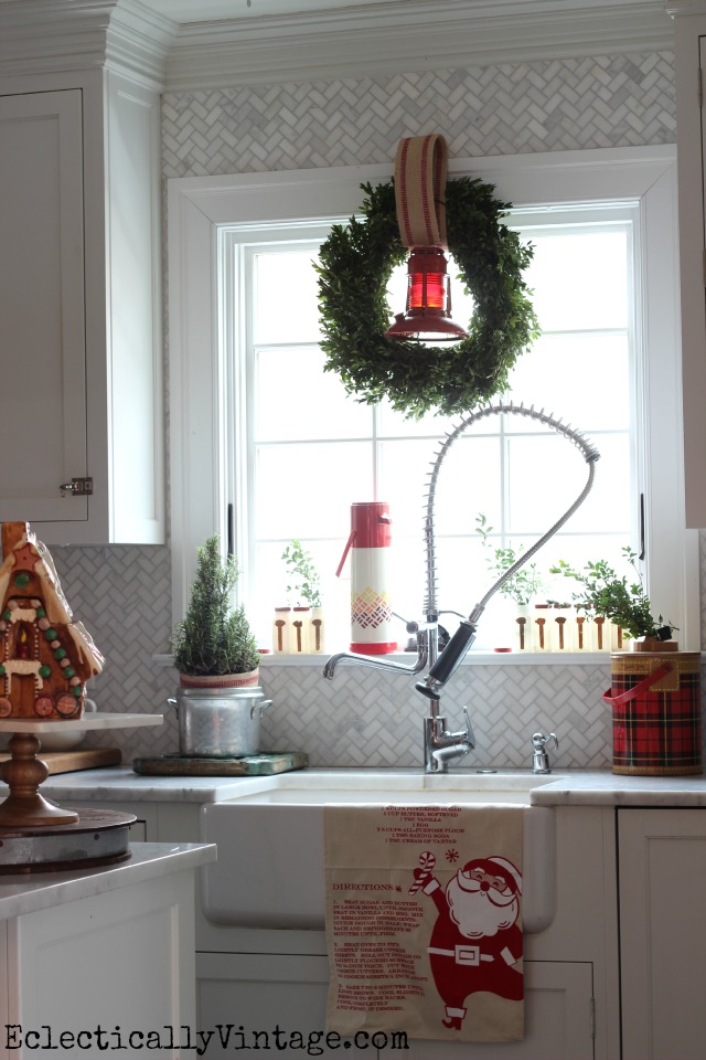 Festive Christmas kitchen window - love the old lantern in the wreath and the thermoses kellyelko.com