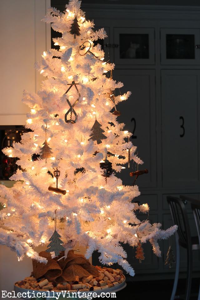 White flocked Christmas tree - love the wine theme with old corkscrews and check out the "tree skirt" kellyelko.com