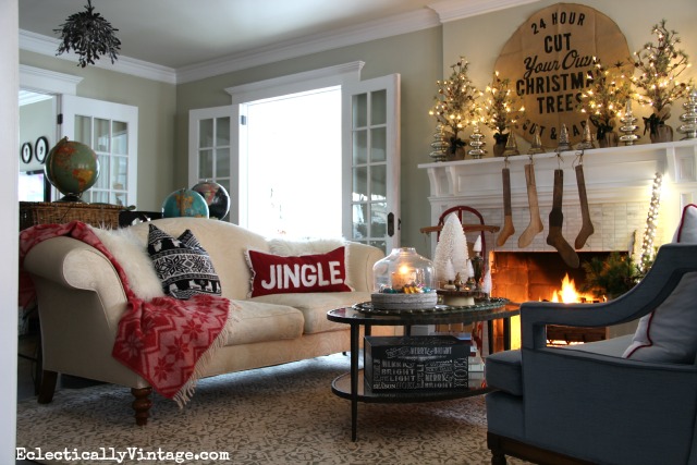 Cozy Christmas living room - love the throw and pillows and that gorgeous glowing mantel kellyelko.com