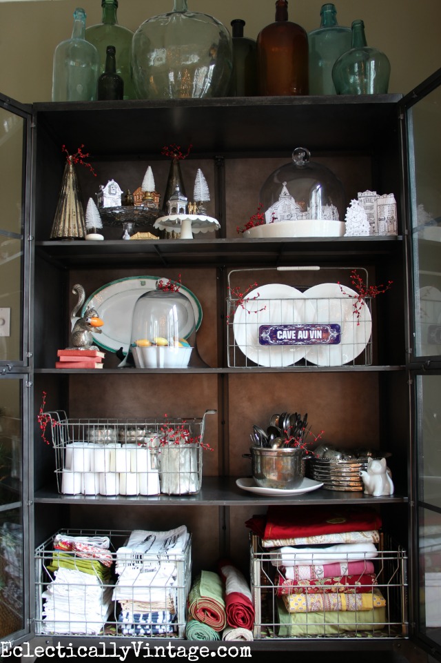 Love the collection of demijohns and this huge industrial cabinet filled with Christmas display ideas kellyelko.com