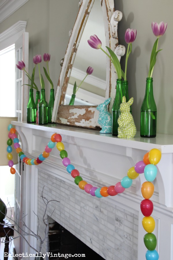 Easter mantel - love the green glass bottles, tulips and that cute egg garland! kellyelko.com