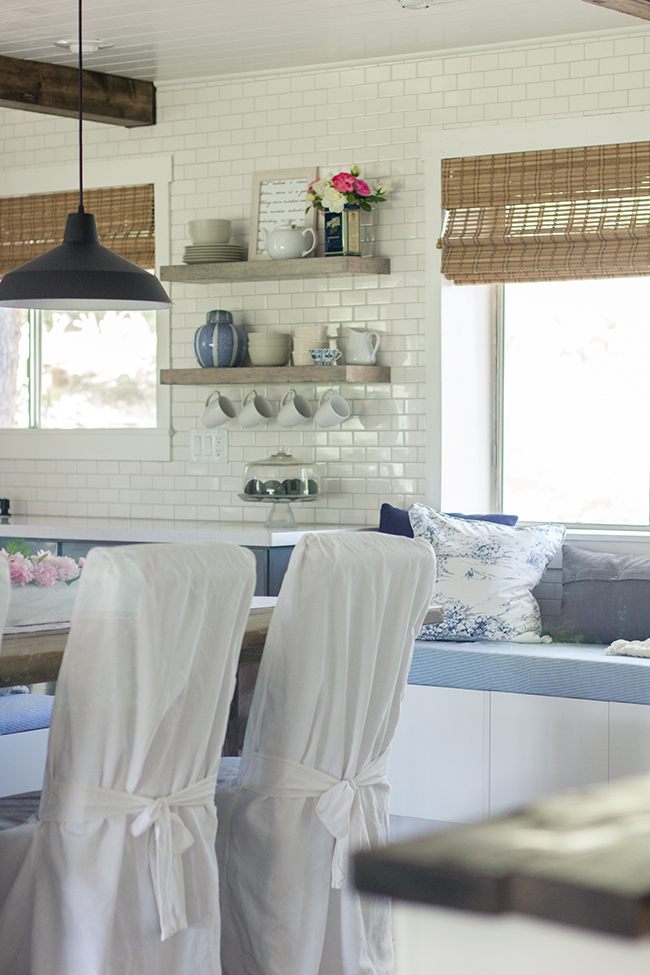 I am in love with this kitchen - subway tile, industrial lights, open shelving - all done on a budget kellyelko.com