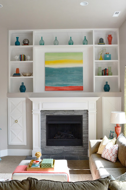 Love these built in cabinets around the fireplace and the color glass display kellyelko.com