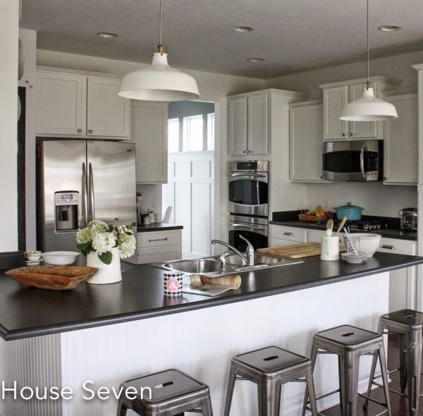 I love a white kitchen with black counters - the industrial lights are a great touch kellyelko.com