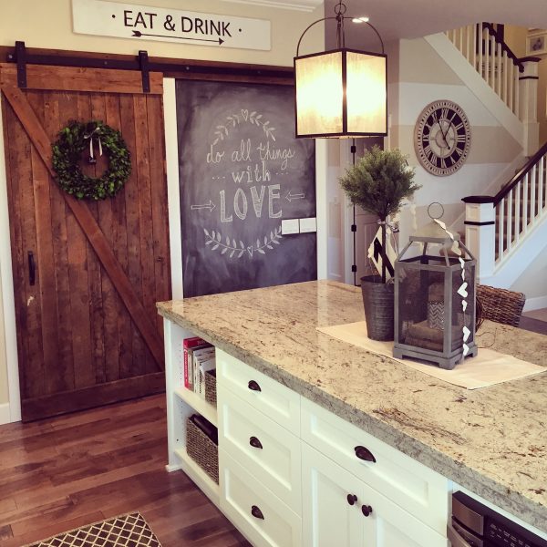 Eclectic Home Tour of Yellow Prairie Interiors - love the rolling barn door and chalkboard wall in this gorgeous white kitchen kellyelko.com