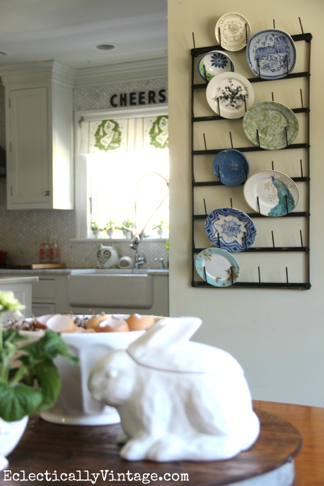 This huge wall bottle drying rack is amazing - I LOVE how she used it to display plates plus she has other creative ways to style it and where to buy it! kellyelko.com #farmhouse #farmhousedecor #farmhousekitchen #platewall #vintagedecor #vintagekitchen #eclecticdecor #colorfuldecor 