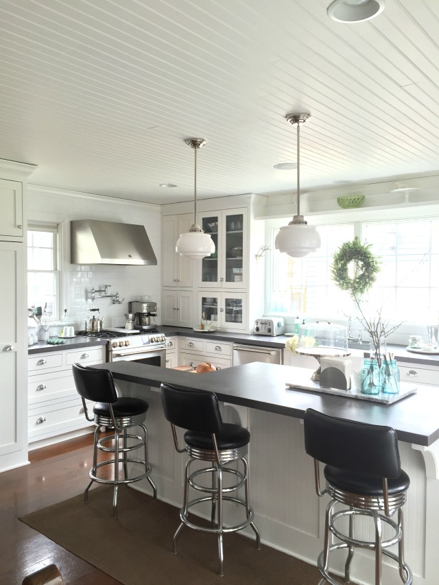 This white kitchen has such great details - the bead board ceiling, the school house lights ... kellyelko.com