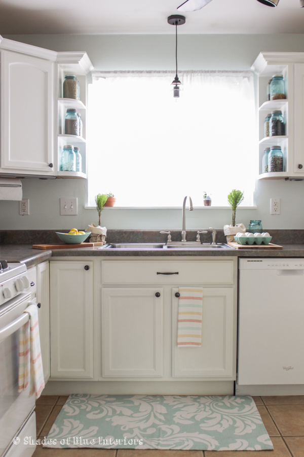 Love this charming white kitchen and the shelves filled with blue mason jars kellyelko.com