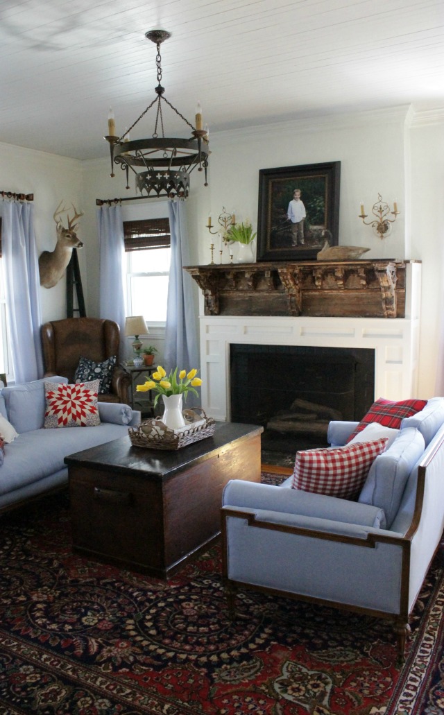 Cozy cottage living room - love the rustic mantel and matching blue sofas kellyelko.com