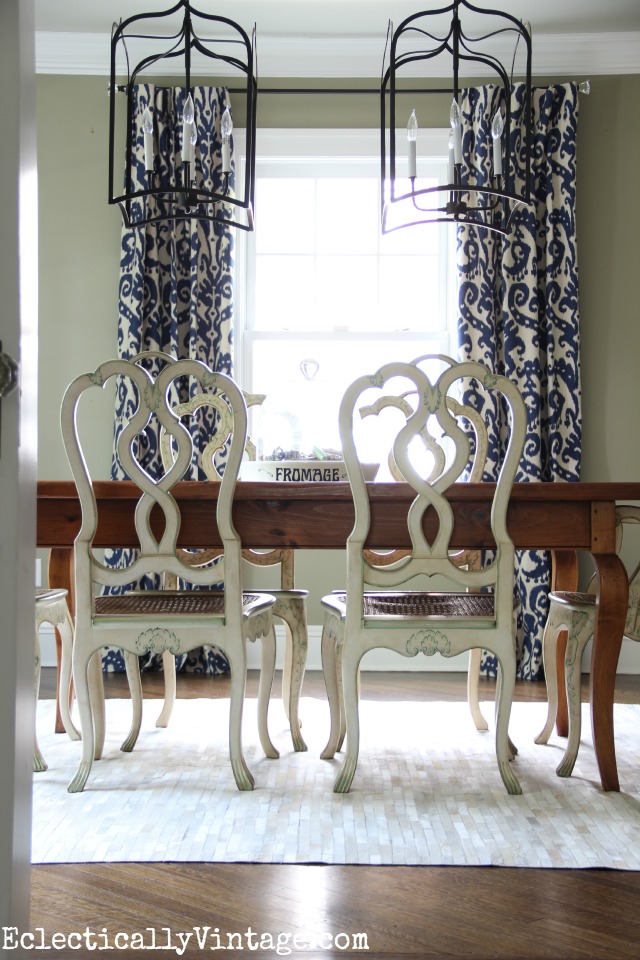 Love the drama of the double lanterns, beautiful drapes, cowhide rug and mismatched furniture in this gorgeous dining room  kellyelko.com