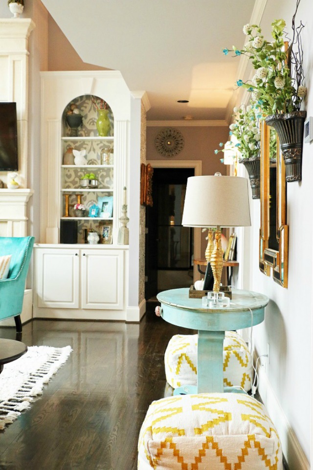 Love the painted cabinet backs and the fun yellow poufs kellyelko.com