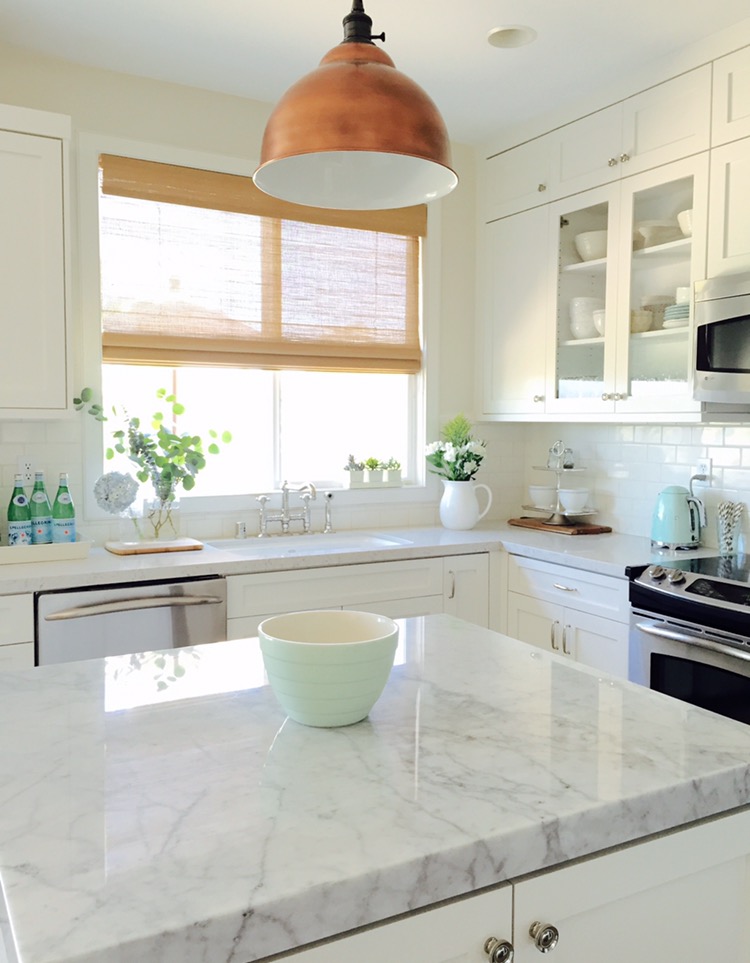 Love this white farmhouse kitchen and that brass light kellyelko.com