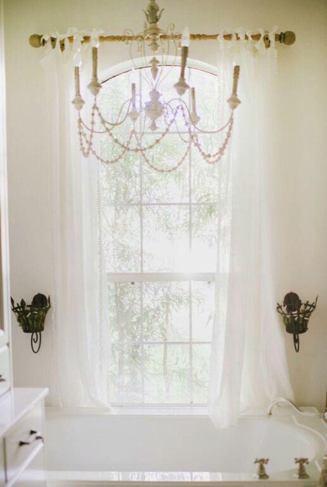 Love the glamorous chandelier over the bathtub