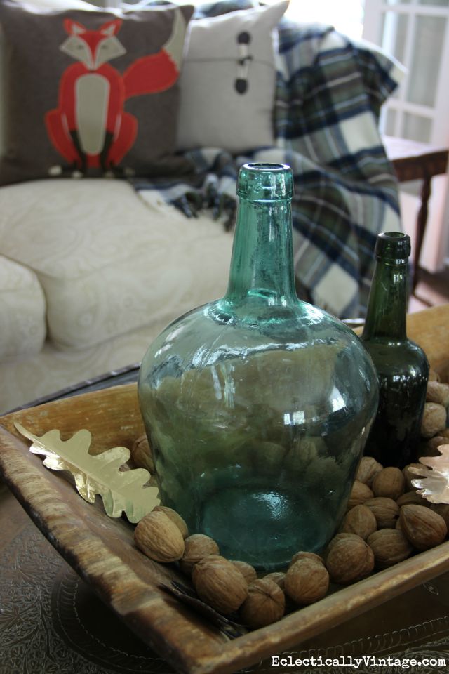 Love this dough bowl centerpiece filled with old bottles and walnuts kellyelko.com