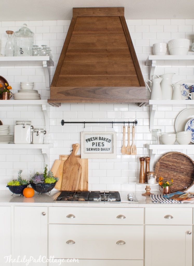 Beautiful white kitchen with wood range hood and open shelves