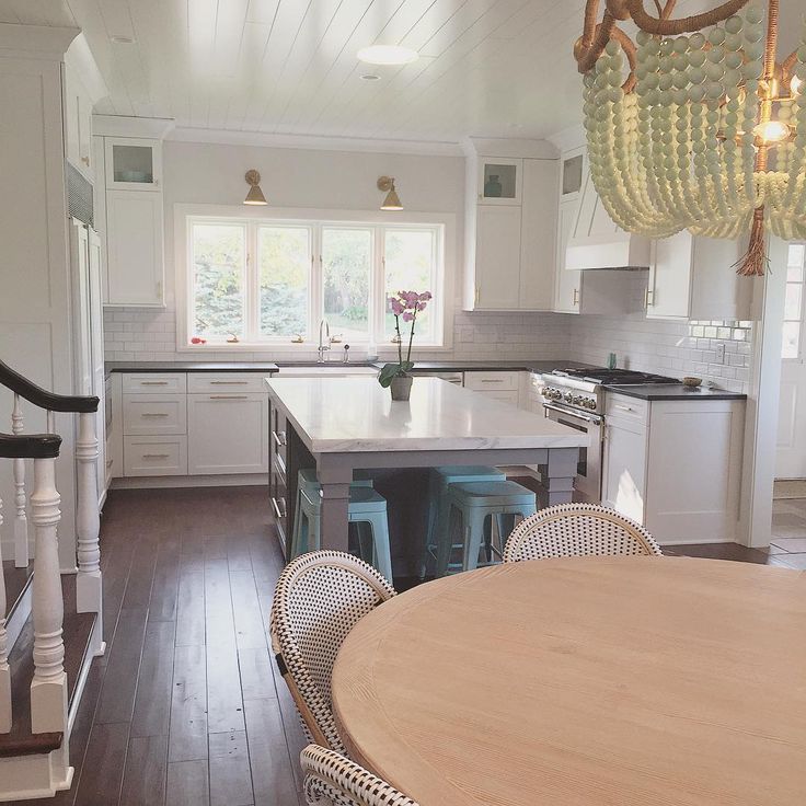 Beautiful white kitchen - love the brass sconces and beaded chandelier kellyelko.com