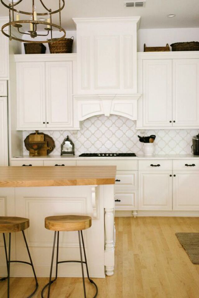 White kitchen with beautiful tile backsplash and butcher block counters 