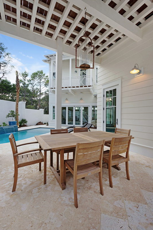 Teak outdoor dining set under a covered patio - love the outdoor chandelier - part of this beautiful coastal home tour kellyelko.com