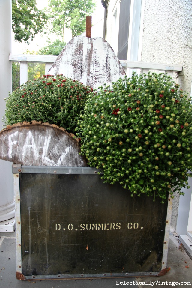 Love this huge old vintage tub filled with mums and a wood pumpkin for fall kellyelko.com