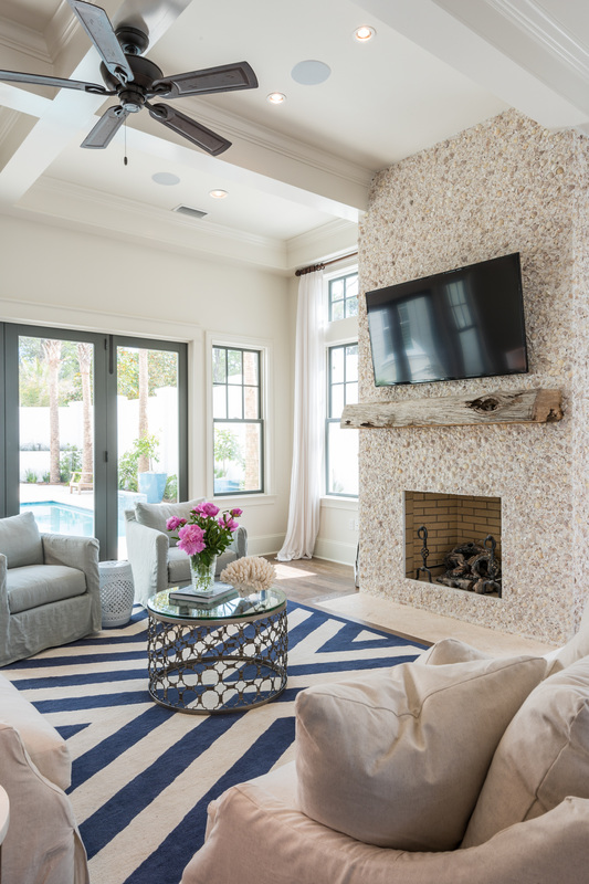 Love the graphic blue and white rug and the fireplace surround made of stucco and seashells! Tour the home kellyelko.com
