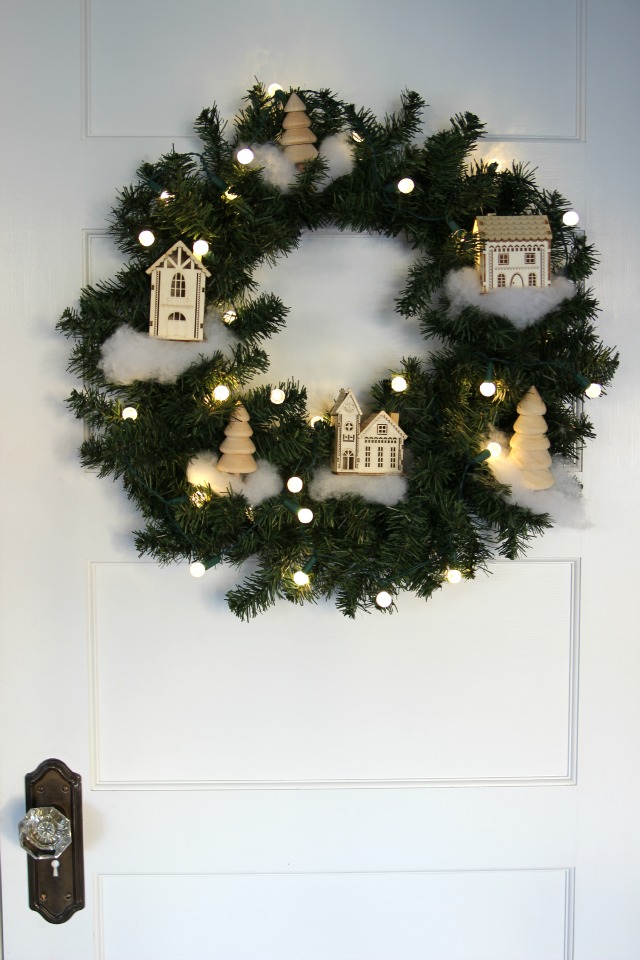 See how to make this Winter Village Wreath for Christmas! Perfect to decorate or give as a gift kellyelko.com