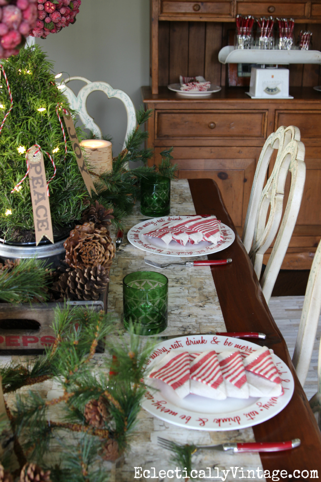 Love this festive Christmas table! The table runner is so fun and the red plates and cutlery kellyelko.com