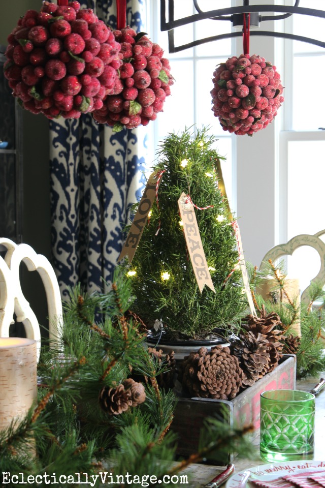 Rustic Christmas centerpiece - love the red kissing balls hanging above kellyelko.com