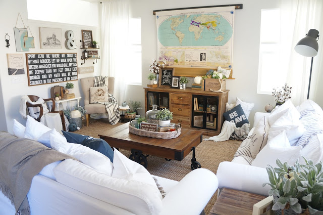 Love this cozy living room and the white slipcovered sofas. The pull down map hides the TV! ecleticallyvintage.com