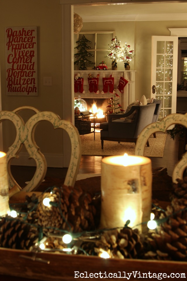 Festive Christmas home at night. Love the simple pinecone centerpiece with string lights kellyelko.com 