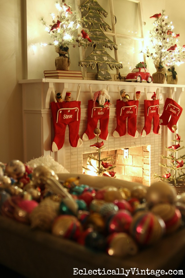 Love this festive Christmas mantel - the long john stockings and the sparkling trees with a flock of red cardinals kellyelko.com