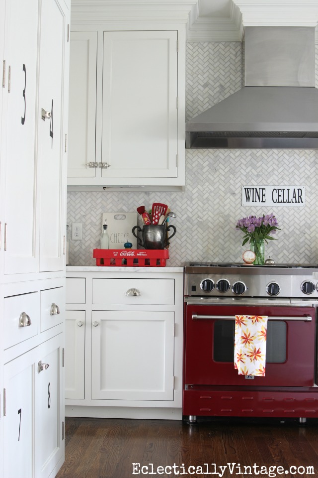 Love this red stove in an all white kitchen and that carrara herringbone backsplash is gorgeous! kellyelko.com