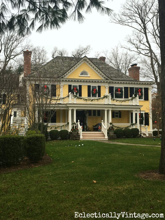 Yellow house decked out for Christmas with wreaths on every window kellyelko.com