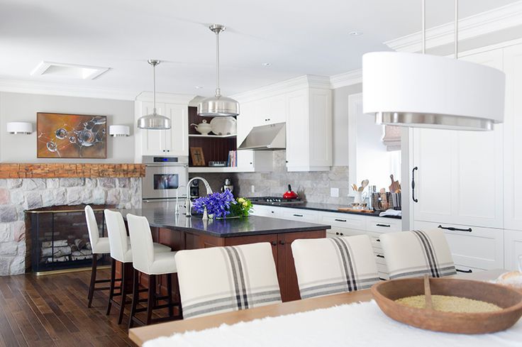 What a beautiful farmhouse kitchen! Love the stone fireplace and rustic beam mantel in the kitchen kellyelko.com