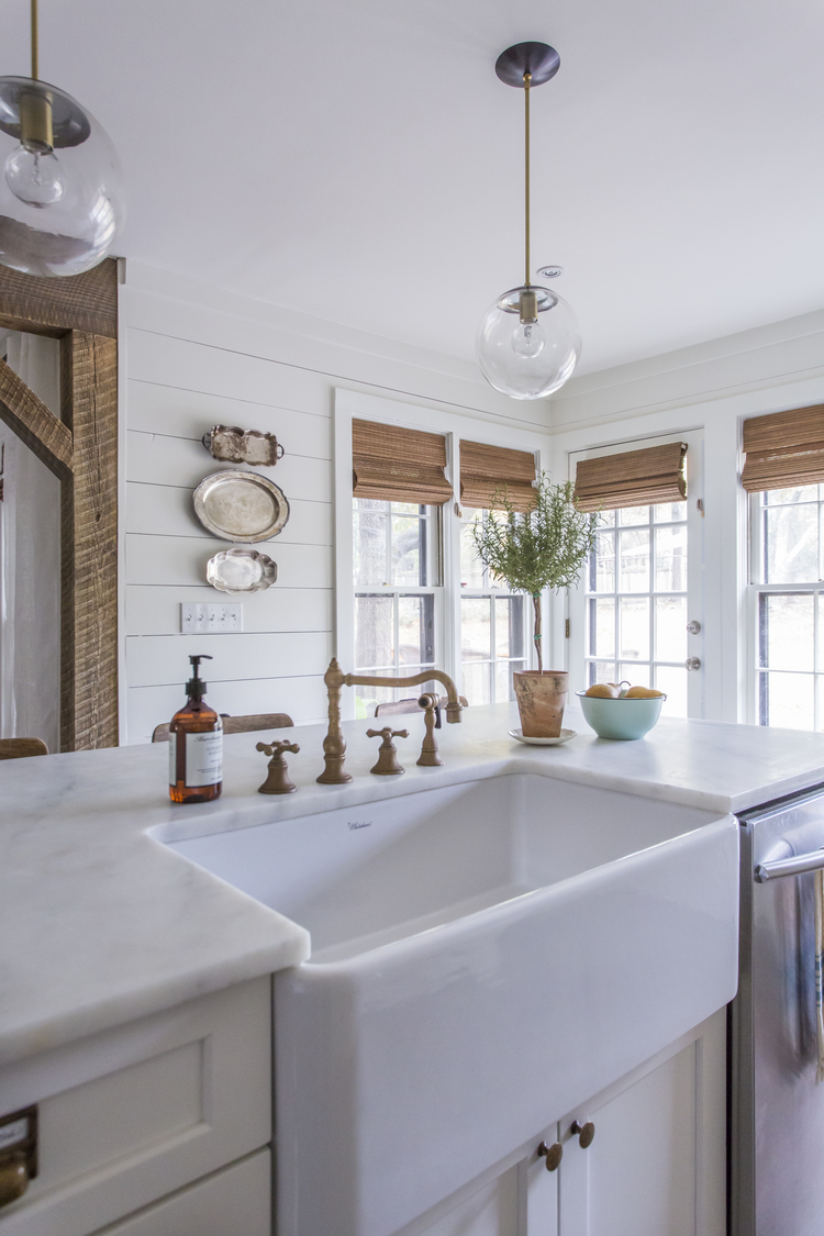 Love the unpolished brass faucet and farmhouse sink in this beautiful white kitchen kellyelko.com