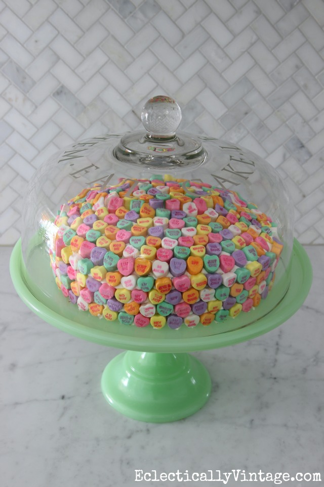 Love this conversation heart cake for Valentine's Day! How cute is that green cake stand too kellyelko.com
