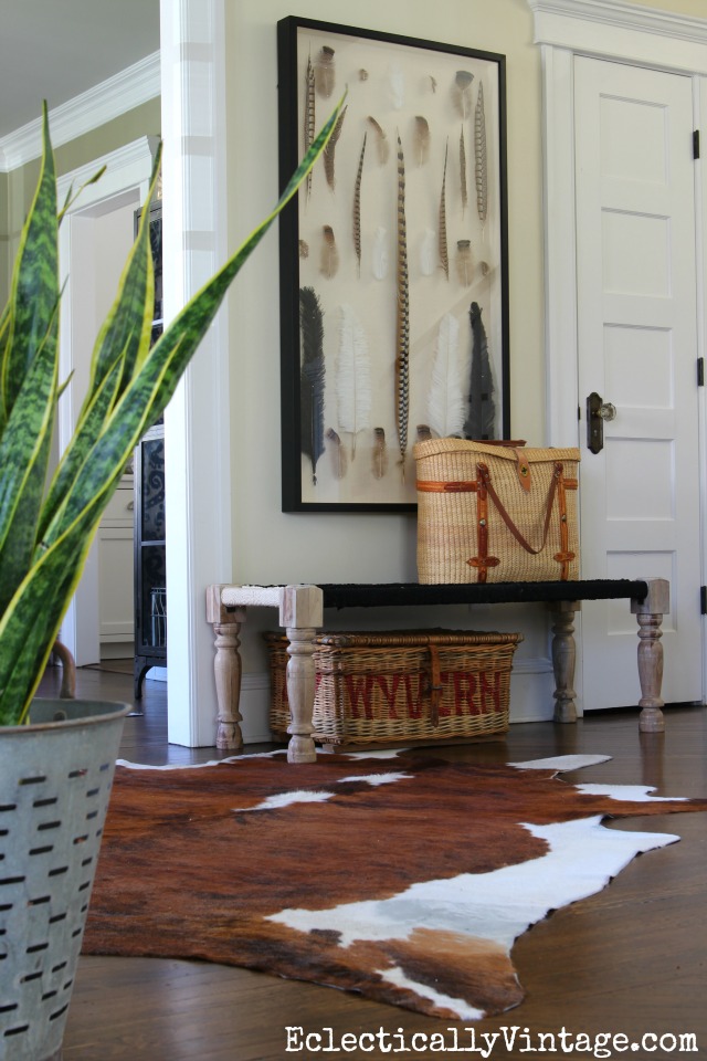 Love the woven bench in this foyer, cowhide rug and the fabulous real feather shadowbox art! kellyelko.com