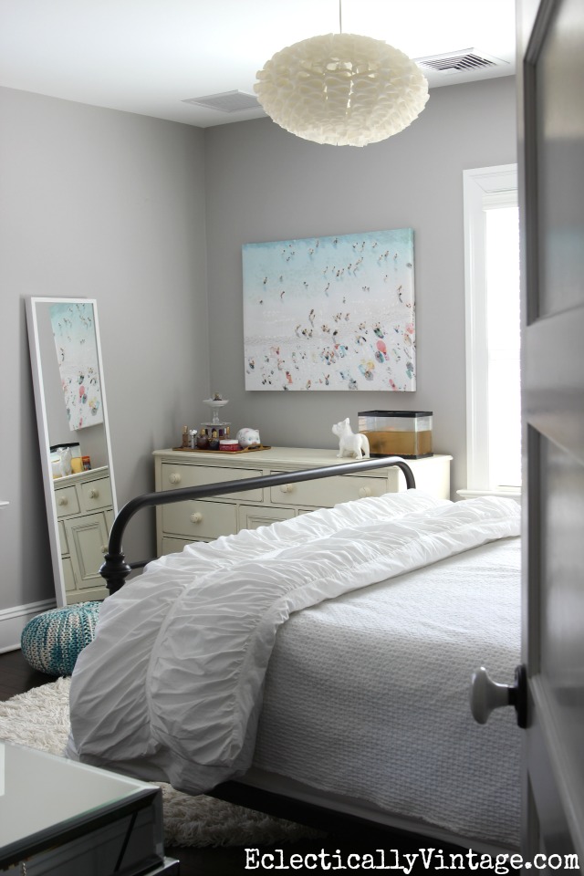 Gorgeous gray bedroom - love the chandelier and the beach art! kellyelko.com