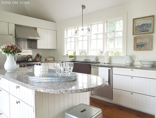 White kitchen - love the wall of windows and the nautical art kellyelko.com