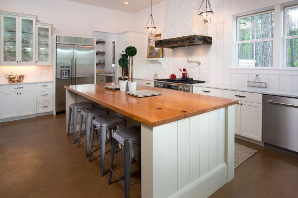 Love this white kitchen with stained concrete floors and wood counter and vertical planked walls kellyelko.com