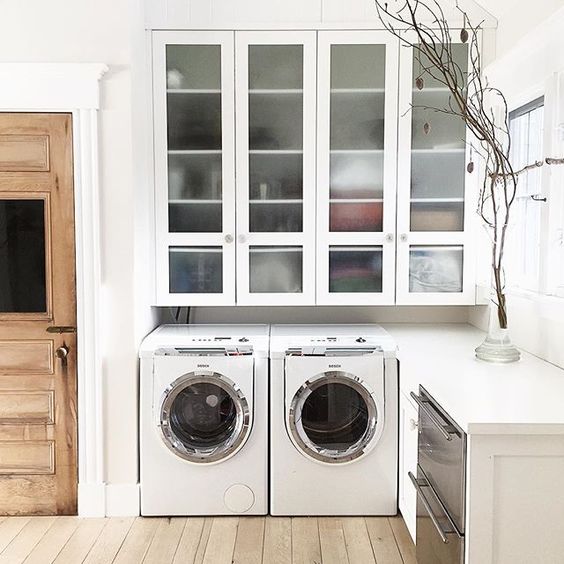 Beautiful laundry room with huge glass front cabinets kellyelko.com