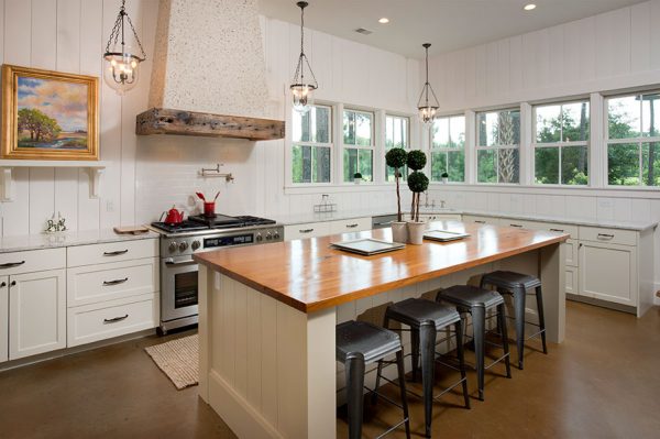 Love this coastal kitchen with tabby shell range hood and vertical plank walls kellyelko.com