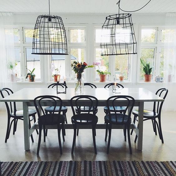 Love this modern and vintage dining room with black bentwood chairs and huge wire chandeliers! part of this amazing Swedish home tour kellyelko.com